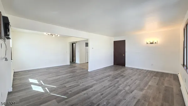 a view of an empty room with wooden floor