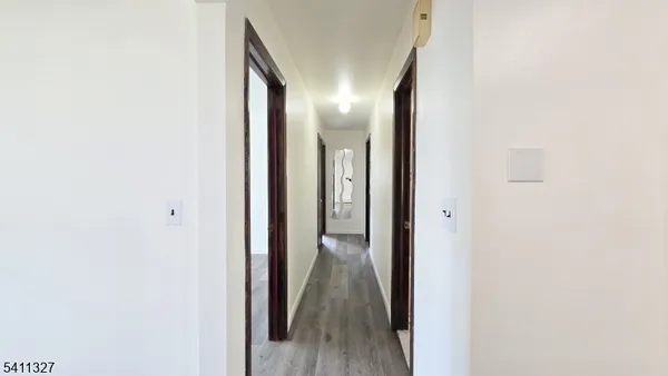 a view of a hallway with wooden floor