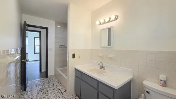a bathroom with a sink a light fixture and a mirror