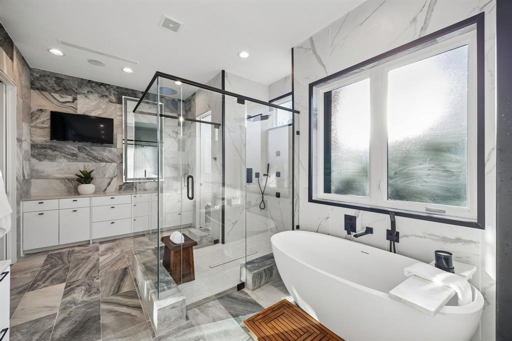 4323 Middleton Road Dallas, TX 75229 - Photo 20 of 40 Primary bath with freestanding tub and expansive walk in shower, finished with floor to ceiling tile and clean, modern lines. A bright, refined space designed for both function and relaxation.