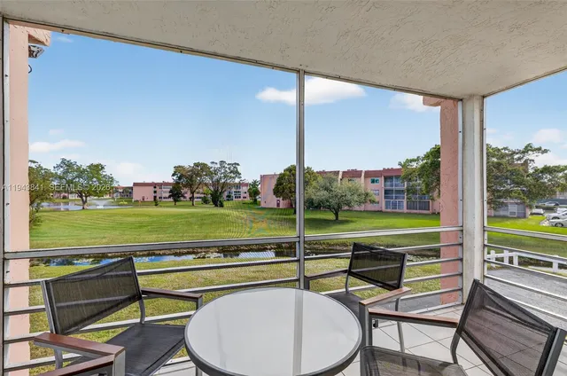 a view of a swimming pool with a table and chairs next to a yard