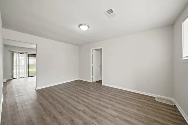 a view of an empty room with wooden floor