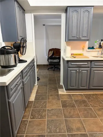 a view of a backyard with large tree and wooden fence
