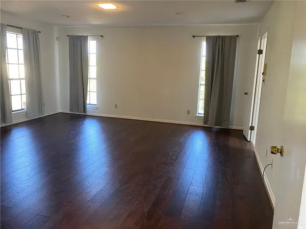 an empty room with wooden floor and a window