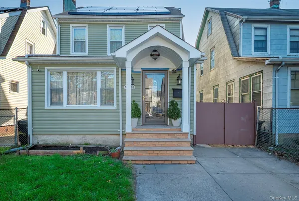 a view of a house with a small yard and wooden fence