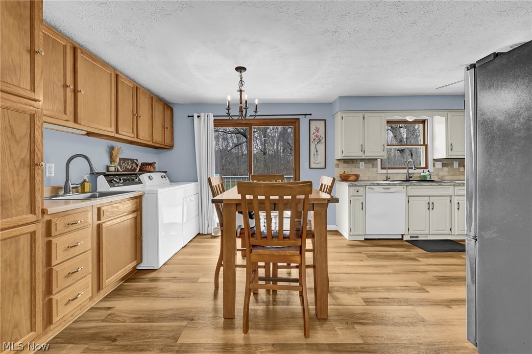 259 East Ohio Avenue Rittman, OH 44270 - Photo 5 of 41 Kitchen with freestanding refrigerator, light countertops, a chandelier, dishwasher, and light wood finished floors