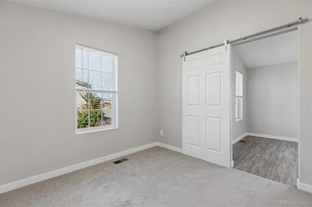 an empty room with windows and closet