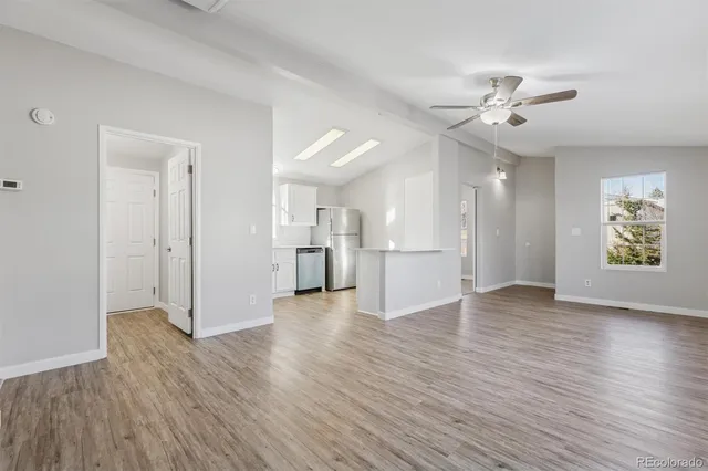 a view of empty room with wooden floor and window