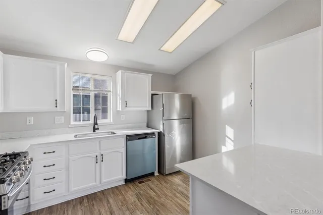 a kitchen with white cabinets and stainless steel appliances