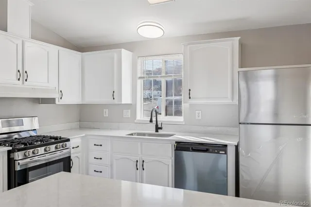 a kitchen with white cabinets and white appliances
