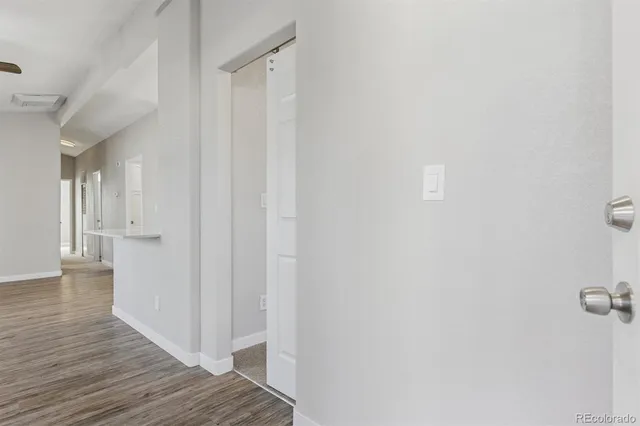 a view of a hallway with wooden floor