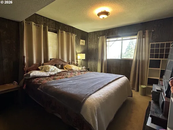 a bedroom with a bed and a large window