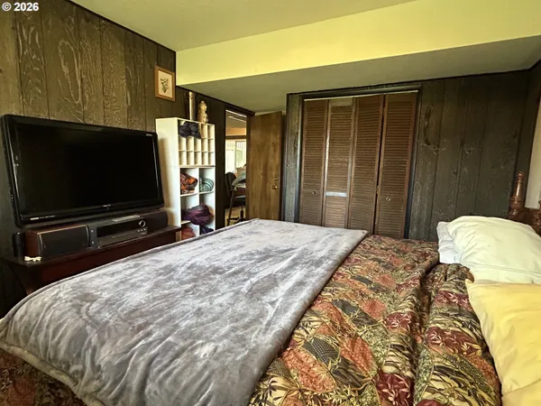 a bedroom with a bed and a flat screen tv