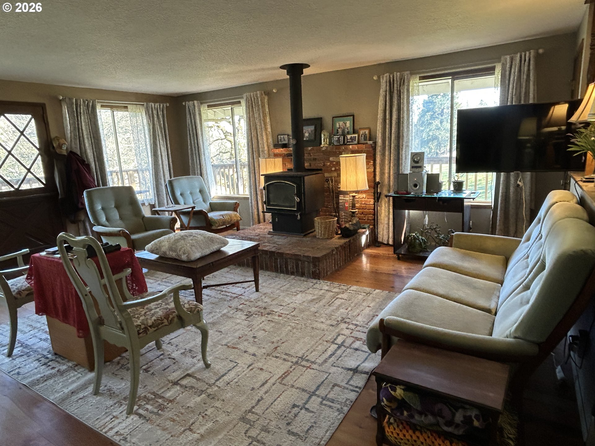 5383 Sunshine Road Roseburg, OR 97470 - Photo 9 of 47 a living room with furniture a flat screen tv and a fireplace