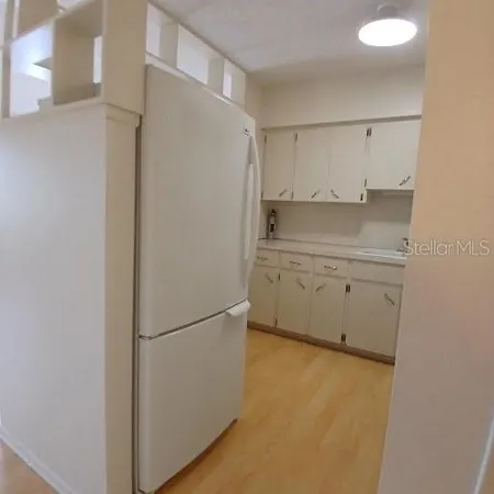 a kitchen with white cabinets and refrigerator