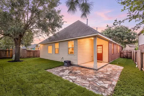 a view of a house with backyard and trees