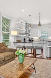 a kitchen with stainless steel appliances granite countertop a sink a refrigerator a stove and white cabinets