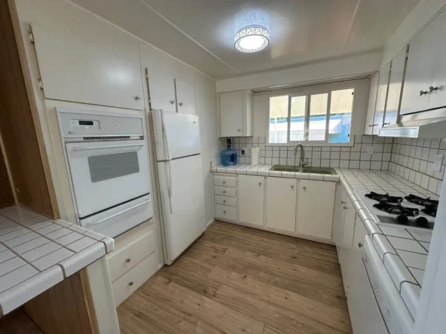 a kitchen with a stove a sink and a refrigerator