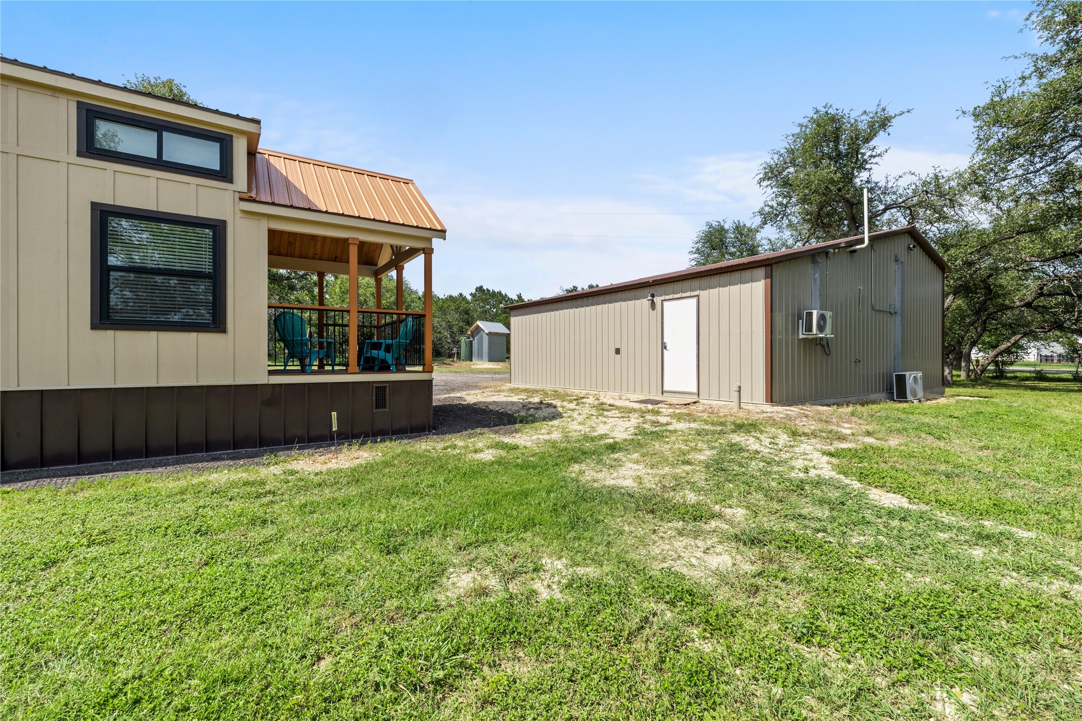 8200 Ranch Road 12 San Marcos, TX 78666 - Photo 27 of 40 A quaint residence with a welcoming covered porch, nestled beside a versatile detached structure amidst a verdant landscape.