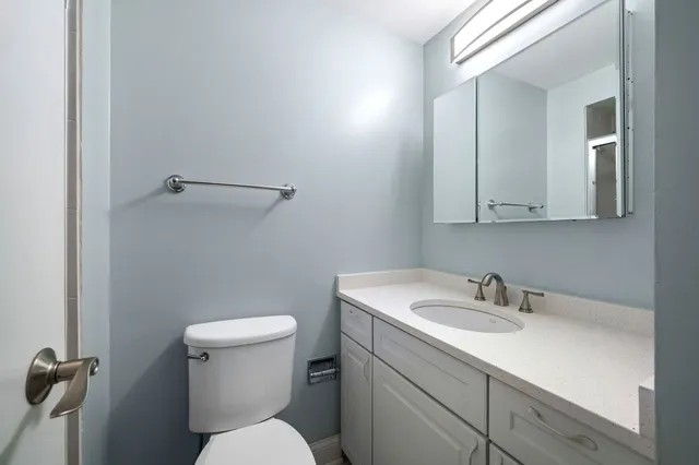 a bathroom with a sink a toilet and a mirror