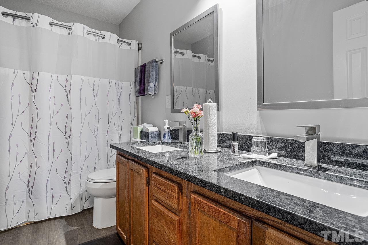 4604 Fox Road Raleigh, NC 27616 - Photo 29 of 29 a bathroom with a granite countertop sink and a mirror