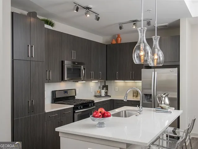 a kitchen with granite countertop a sink stainless steel appliances and cabinets