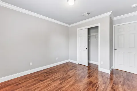 a view of an empty room with wooden floor