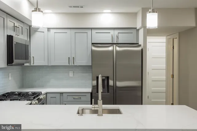 a kitchen with stainless steel appliances granite countertop a refrigerator and a sink