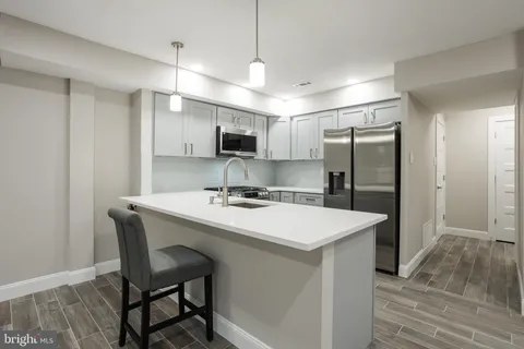 a kitchen with kitchen island a sink stove and refrigerator