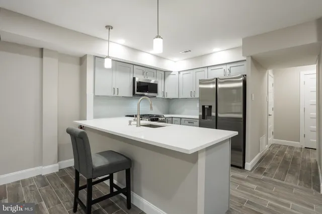 a kitchen with kitchen island a sink stove and refrigerator