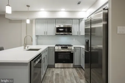 a kitchen with stainless steel appliances a stove a sink and a refrigerator