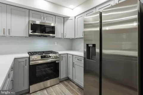 a kitchen with stainless steel appliances and white cabinets