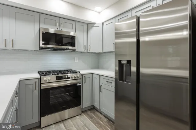 a kitchen with stainless steel appliances and white cabinets
