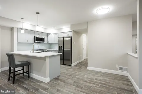a kitchen with a sink cabinets and wooden floor