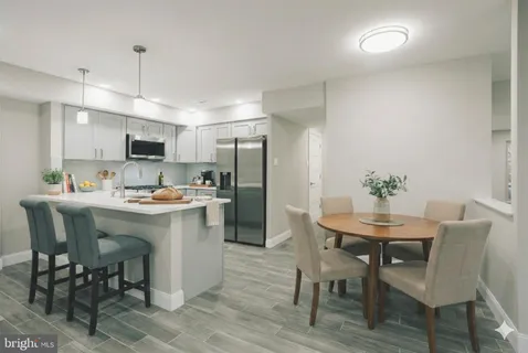 a kitchen with a dining table chairs refrigerator and cabinets