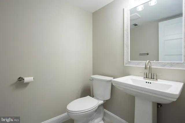 a bathroom with a sink a toilet and a mirror