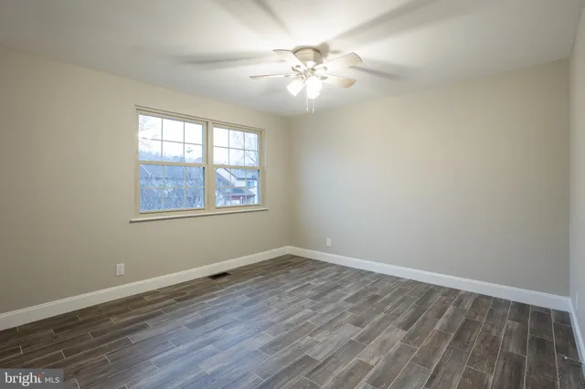 a view of wooden floor and chandelier fan in a room