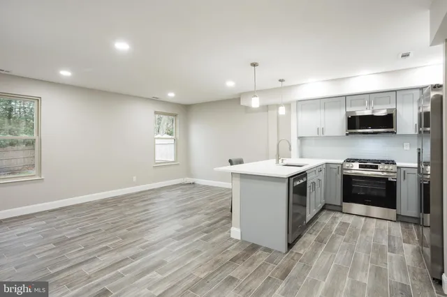 a kitchen with a sink and steel appliances