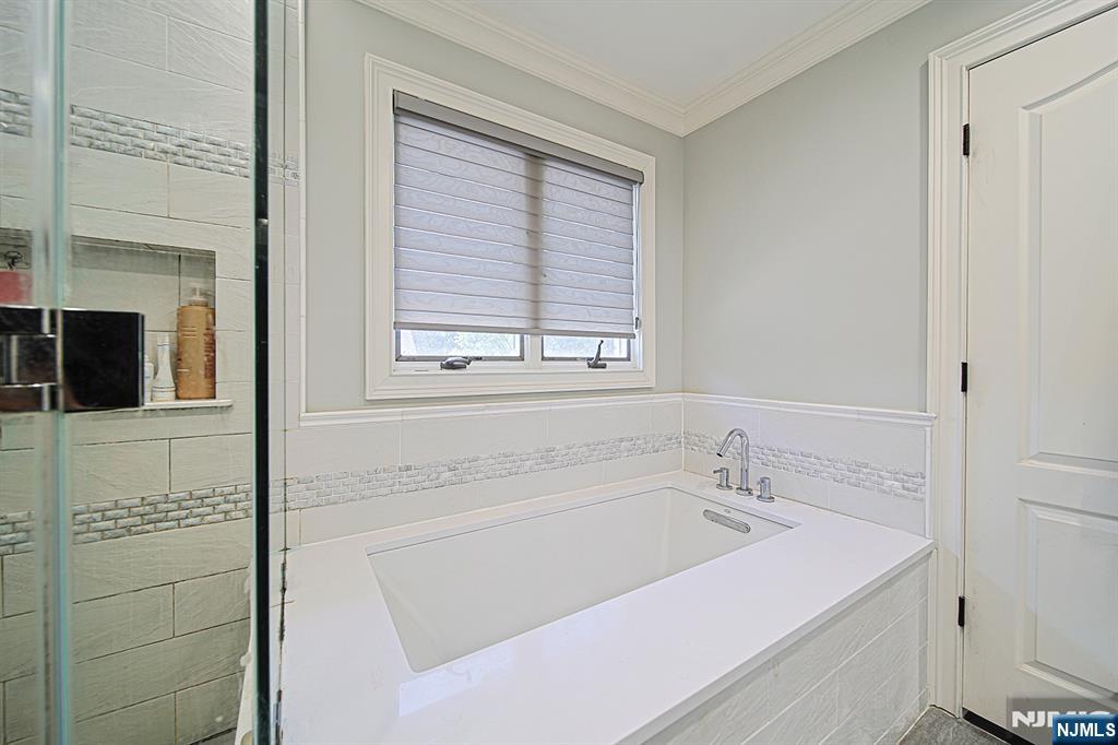 897 Virgil Avenue Ridgefield, NJ 07657 - Photo 36 of 50 a bathroom with a tub sink and mirror