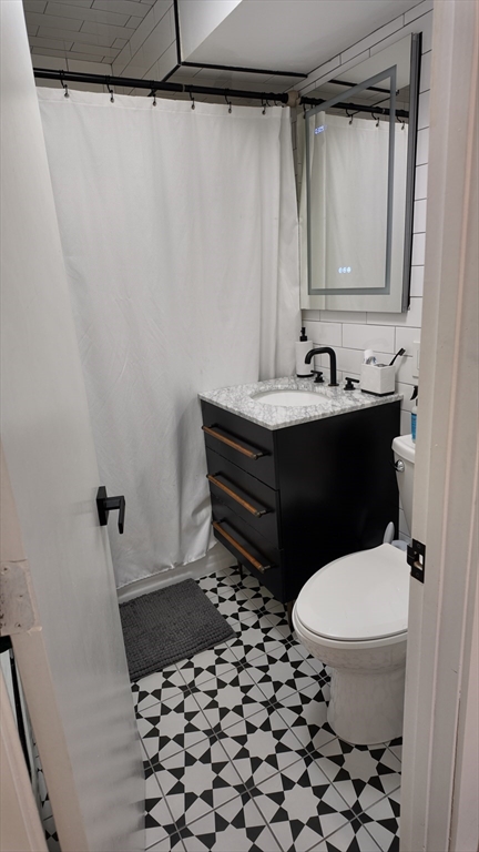 99 Cluff Crossing Road, Unit E9 Salem, NH 03079 - Photo 6 of 13 a bathroom with a sink a toilet a shower and a mirror