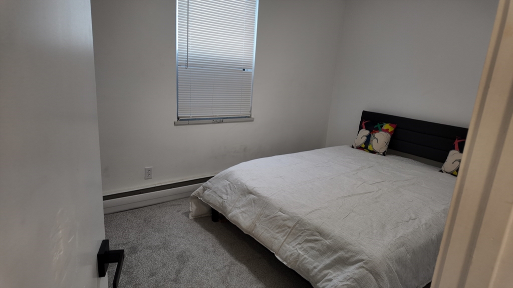 99 Cluff Crossing Road, Unit E9 Salem, NH 03079 - Photo 7 of 13 a bedroom with a bed and wooden floor