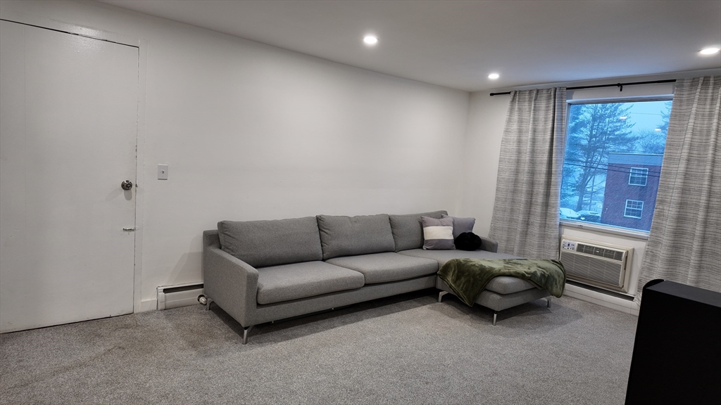 99 Cluff Crossing Road, Unit E9 Salem, NH 03079 - Photo 10 of 13 a living room with furniture and a window