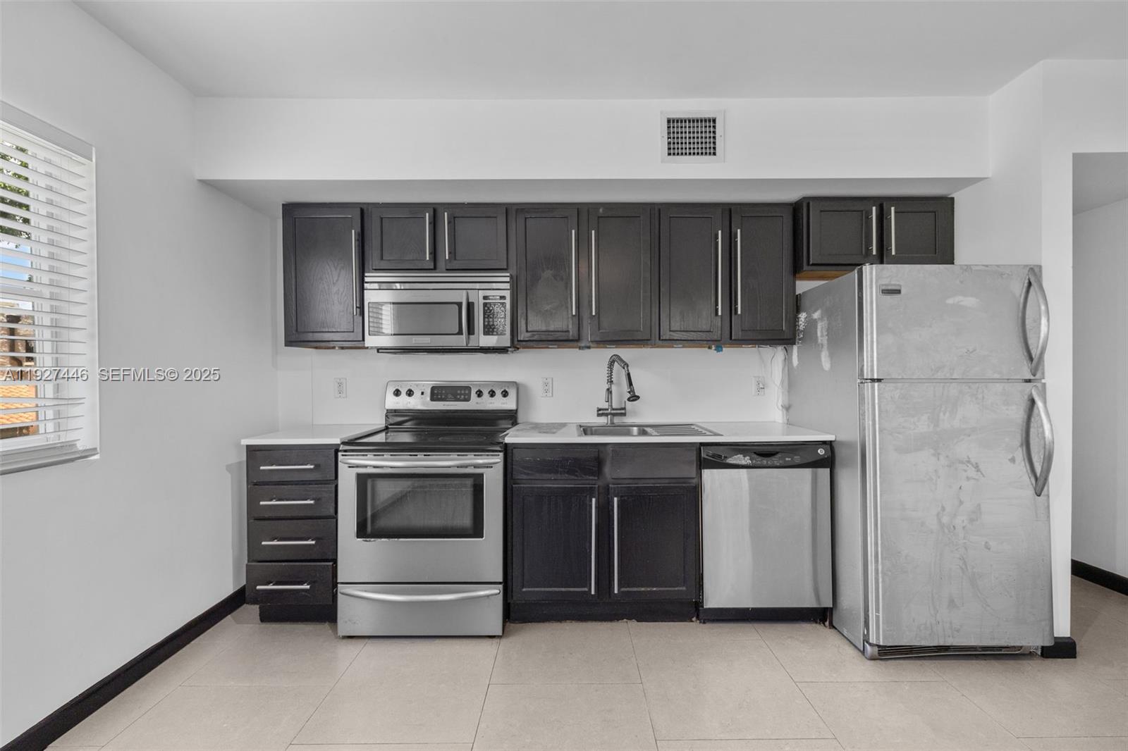 1876 Southwest 11th Terrace, Unit 206 Miami, FL 33135 - Photo 1 of 15 a kitchen with stainless steel appliances granite countertop a refrigerator stove and a sink