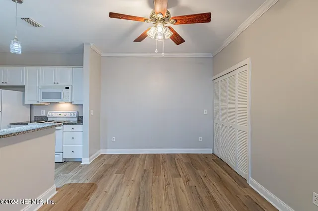 a view of a kitchen with a sink and dishwasher with wooden floor