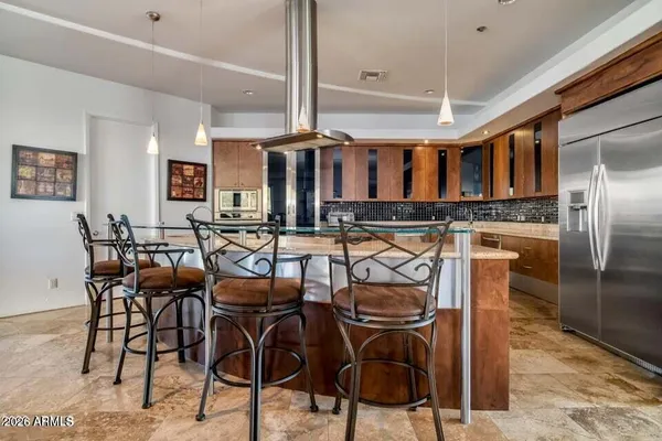 a large white kitchen with kitchen island a large counter top stainless steel appliances and cabinets