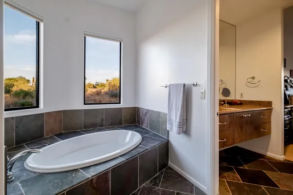 a view of a lake with a floor to ceiling window and potted plants