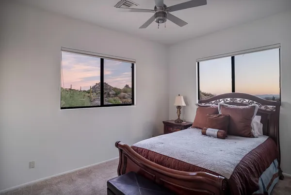 a bedroom with a bed and a large window