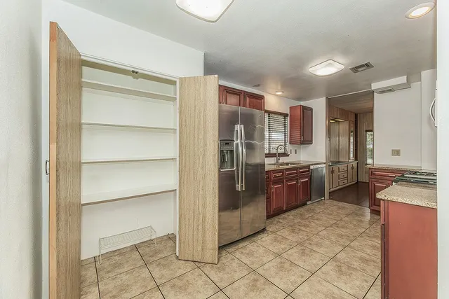 a kitchen with stainless steel appliances granite countertop a refrigerator and a sink