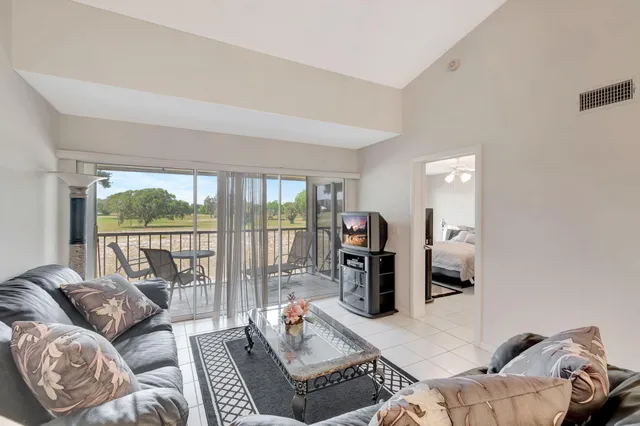 a living room with furniture and a floor to ceiling window