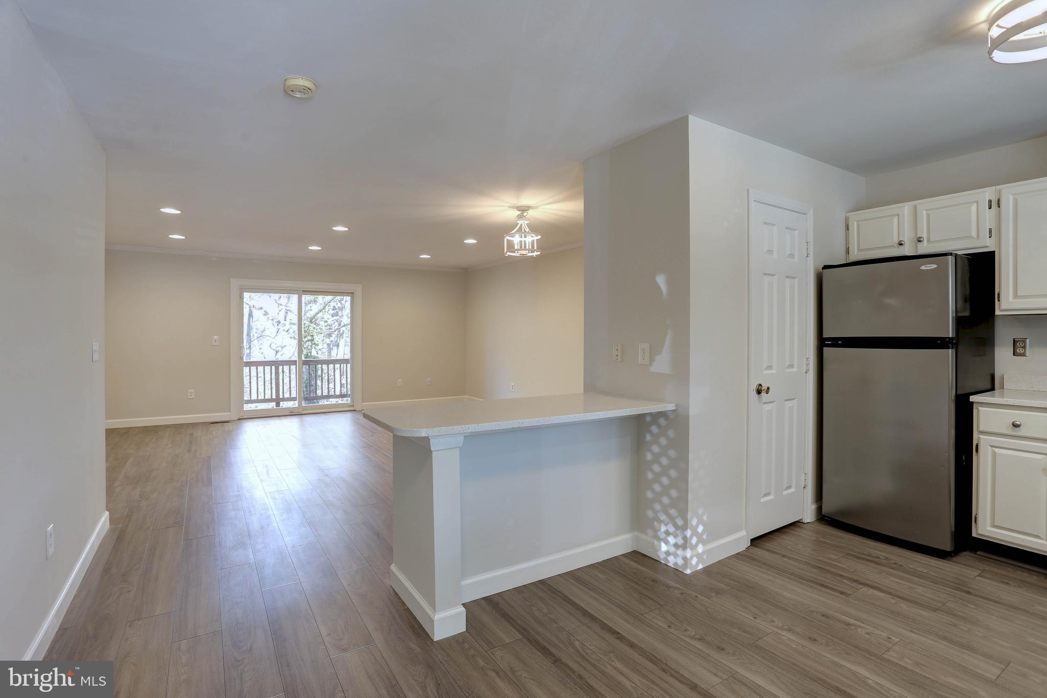 20 Bryans Mill Way Baltimore, MD 21228 - Photo 8 of 36 a view of a kitchen with a refrigerator and wooden floor